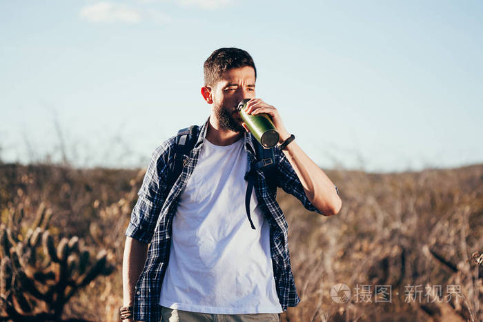 在巴西 Caatinga 徒步旅行时, 男子休息喝瓶装水