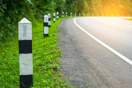 黑色和白色的里程碑与绿草路边, 树木路边的背景.下一个步骤的概念.