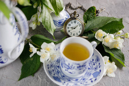 盛开的茉莉花花和一个链条上的机械时钟的茶叶集