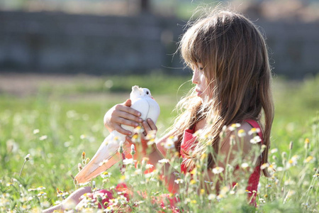 小女孩捧着一只活的白鸽