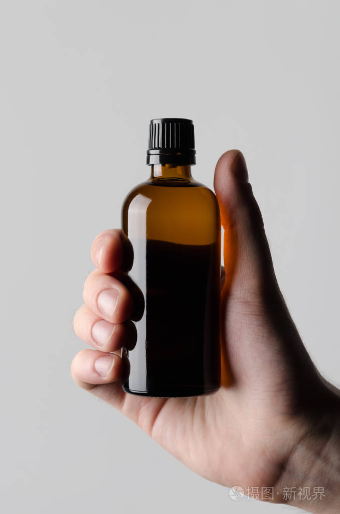 制药瓶模拟-男性手拿着一个药瓶在灰色的背景下