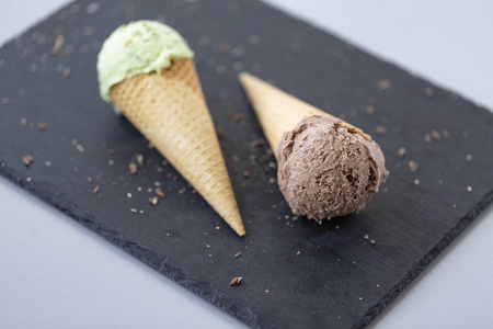 巧克力和开心果冰淇淋在华夫饼锥体, 与坚果和片断的黑巧克力