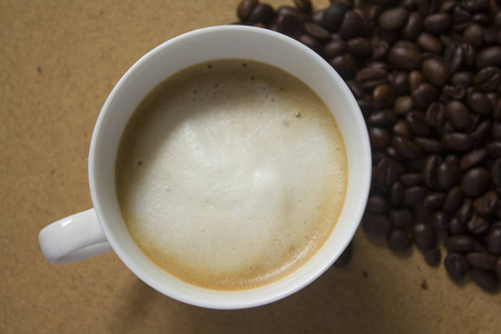咖啡杯和咖啡豆中的牛奶泡沫