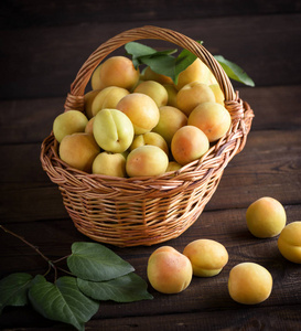在一个木桌上的棕色柳条篮子成熟的黄杏, 关闭