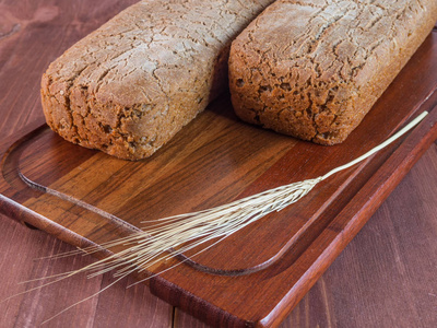 自制的烤面包和一个切板上的小麦茎