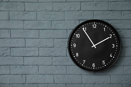 在砖墙上的现代时钟。时间概念
