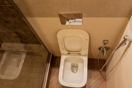 现代宽敞的浴室配有带马桶和水槽的明亮瓷砖。侧面视图