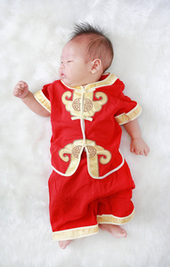 中国农历新年佳节白色毛皮背景的旗袍婴儿男婴