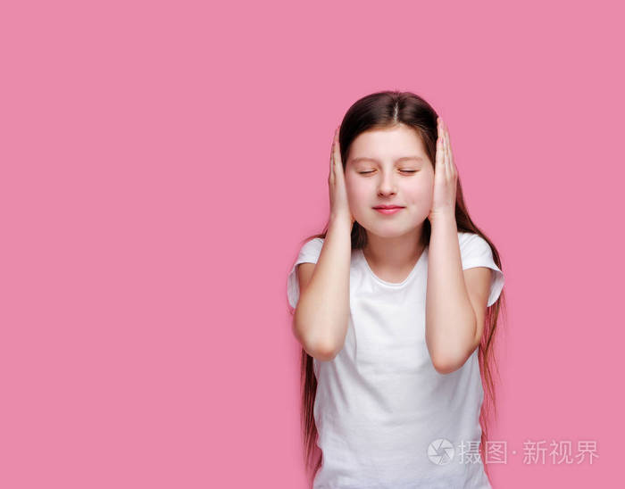 十几岁的黑发少女用手捂着耳朵