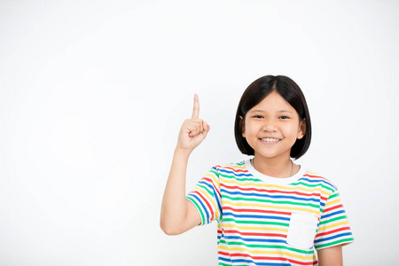 美丽的小亚洲女孩的肖像微笑热情, 举起她的手, 指着手指向上