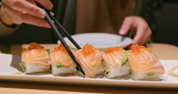 妇女在餐馆享用日本寿司