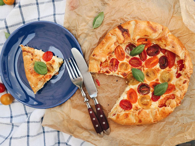 蓝盘子里有西红柿和罗勒叶子的披萨片