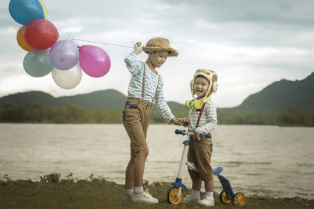 海滩上有气球和自行车的亚洲儿童快乐