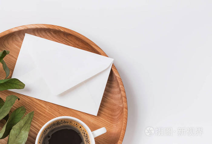木托盘上的信封和咖啡