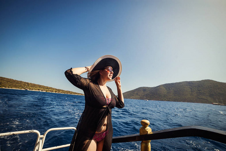 美丽的女孩在帽子放松在船上, 看着岛上。土耳其旅游职业巡回赛