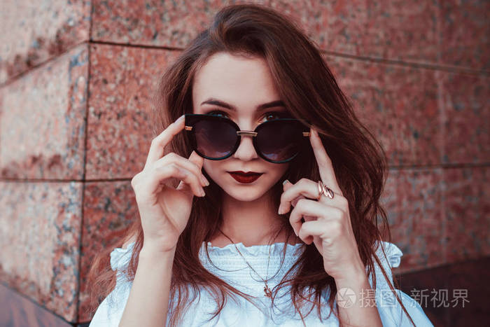 在城市街道上的一个美丽的时尚女人在太阳镜的户外肖像.