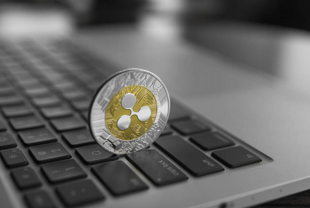 银金波纹硬币在笔记本电脑键盘特写。Blockchain 矿业。数字货币和虚拟 cryptocurrency 概念。加密货币投资。