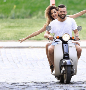 年轻夫妇骑摩托车在城市