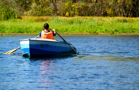 人在救生衣划船在清澈的水