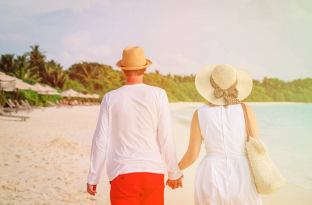 幸福恩爱的夫妻在海滩上行走