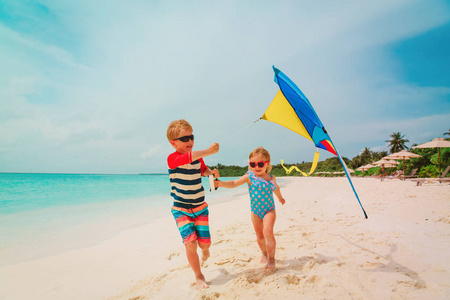 孩子小男孩和女孩在热带海滩上放飞风筝
