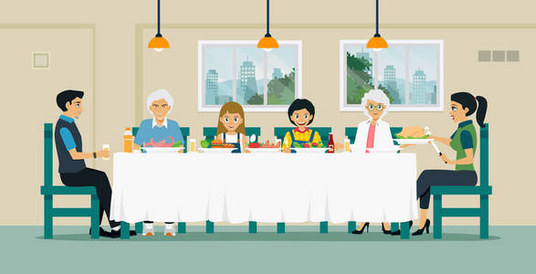 家庭坐在一起吃食物在桌与祖父和祖母