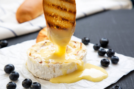 烤乳酪奶酪在纸上黑色背景, 侧面视图.特写照片