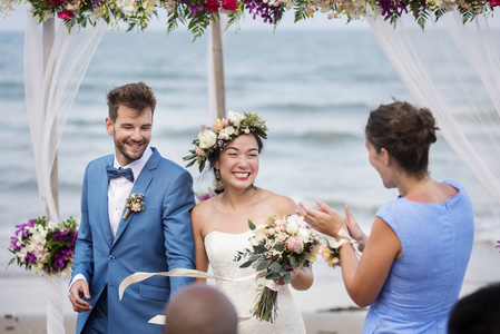 在海滩举行婚礼的年轻幸福夫妇