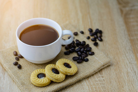 一杯咖啡与饼干在木桌与模糊背景