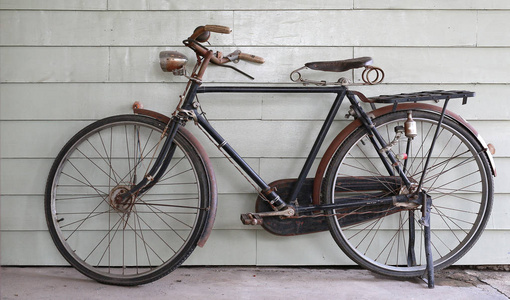 灰色木墙背景下的旧古自行车特写