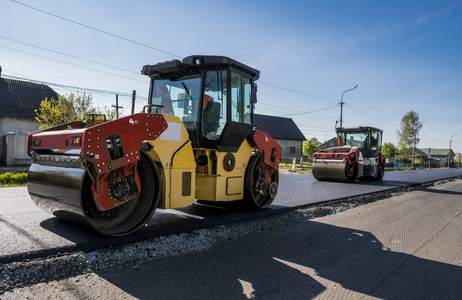 重型振动压路机在沥青路面工作的新道路施工现场。修复