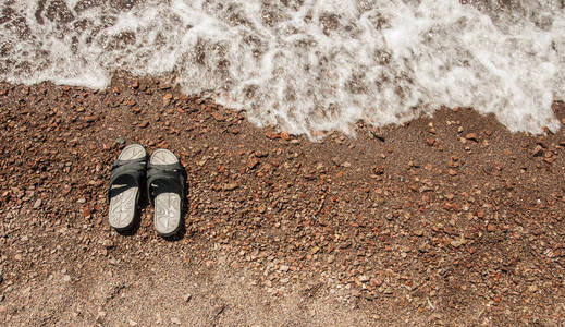 在海滩和海浪上翻转拖鞋凉鞋。暑假