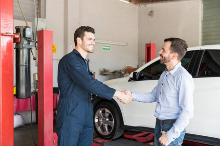 满足客户在汽车修理厂与汽车修理工握手