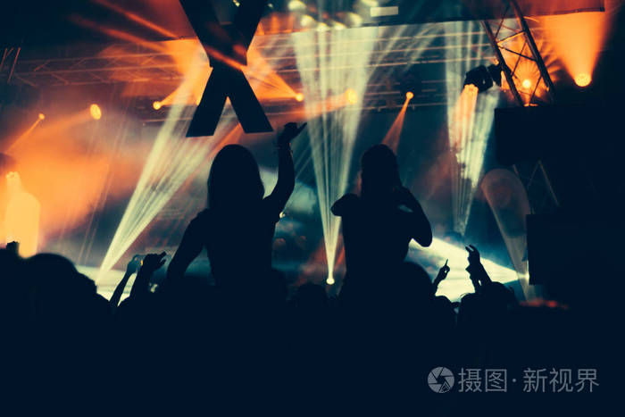 在明亮的舞台灯光音乐会剪影人群