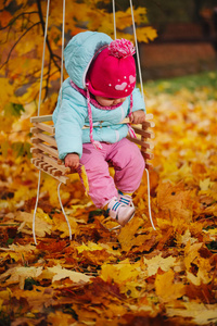 秋季公园秋千上的小女孩