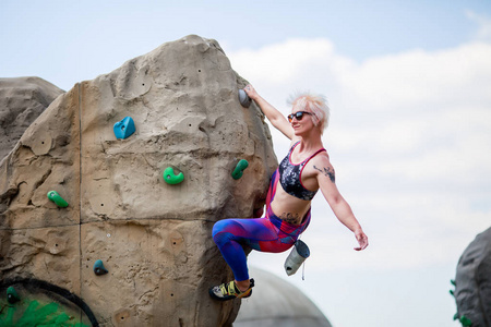 运动女孩的照片, 从事攀登巨石对天空与云