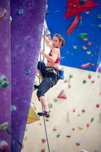 在攀岩墙上锻炼的年轻女孩的照片
