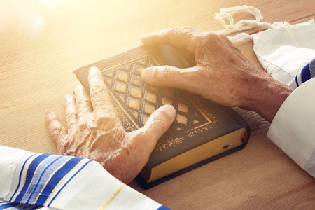 老犹太人手里拿着一本祈祷书, 祈祷着, 挨着 tallit。犹太传统符号。Rosh 新年 犹太新年假期, 安息和赎罪日概念
