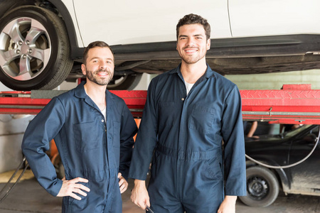 汽车修理厂微笑着自信的男性力学肖像
