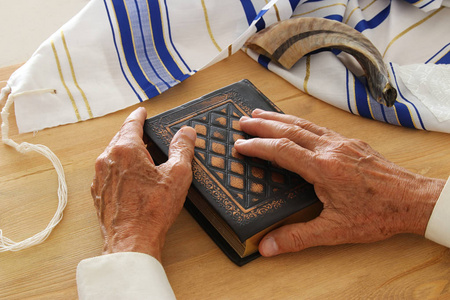 老犹太人手拿着祈祷书, 祈祷, 旁边 tallit 和羊角号 垫铁。犹太传统符号。Rosh 新年 犹太新年假期 和赎罪日