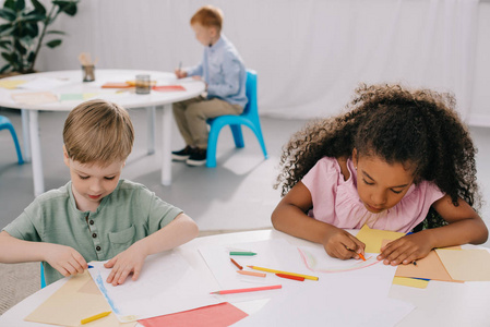 多文化学龄前儿童在课堂上画铅笔