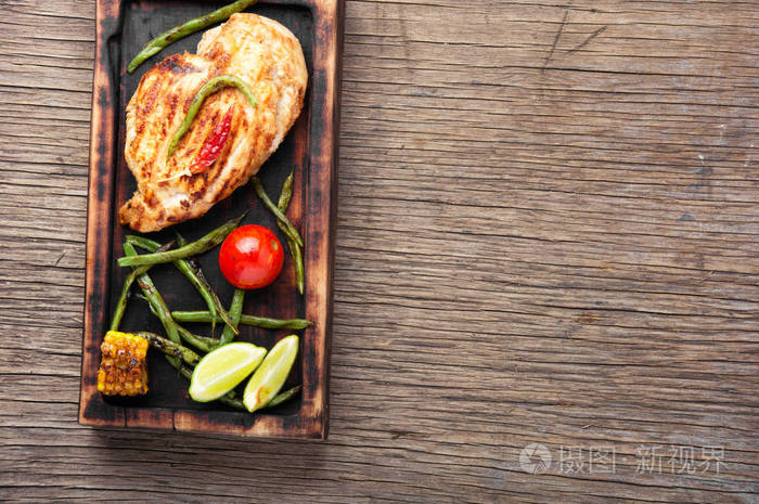 烤鸡胸配香料在厨房板上