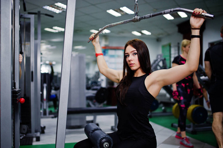 年轻的运动女孩在健身房锻炼。健身妇女做锻炼
