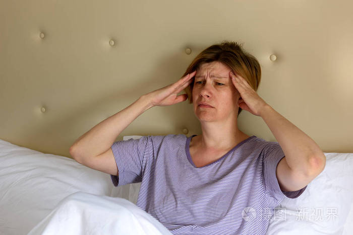 一个女人觉得不舒服, 早上坐在床上.头痛.limacteric