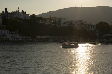 从爱琴海的斯亚索斯镇的背光视图与通过水的旅游船, 希腊