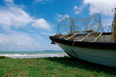 搁浅在岸上的渔民船.晴朗的晴天和多云的天空背景照片