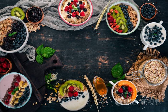 麦片粥, 酸奶, 水果和浆果在盘子里。早餐。在黑色的木质背景。顶部视图。文本的可用空间