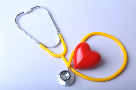 红色心脏和医疗听诊器在书桌