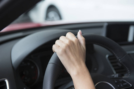 一个穿时髦指甲的女孩的手就在一辆轿车的车把上。特写