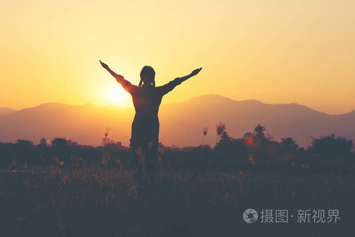 自由欢呼的女孩举起双臂享受宁静的日落在胜利的姿势与手臂伸展照片